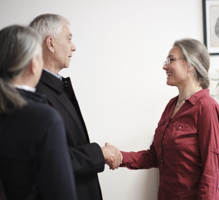 Begrüßungsszene in der Praxis für Paar- und Sexualberatung in Innsbruck: Dr. Friederike Kleinknecht empfängt Klient:innen mit einem freundlichen Händedruck.